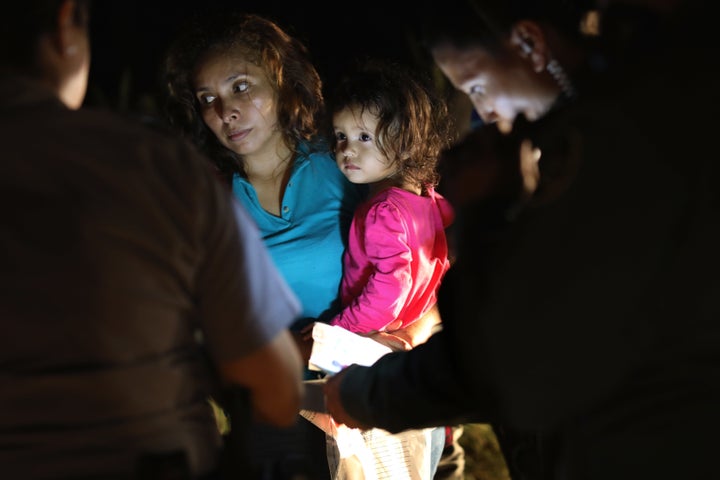 A Honduran mother holds her 2-year-old as U.S. Border Patrol agents review their papers near the U.S.-Mexico border on June 12 in McAllen, Texas.