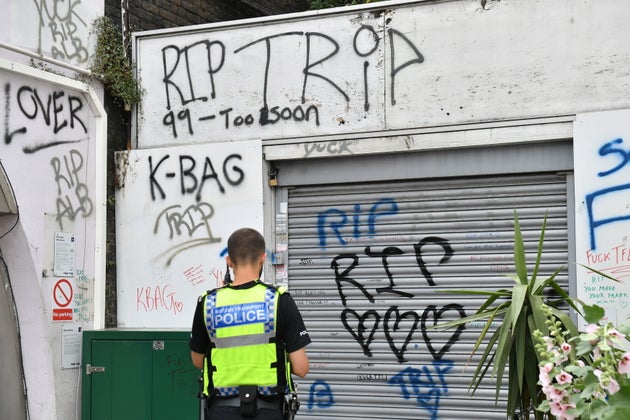 Flowers and three spray cans lay next to shutters, which have been spray-painted with 