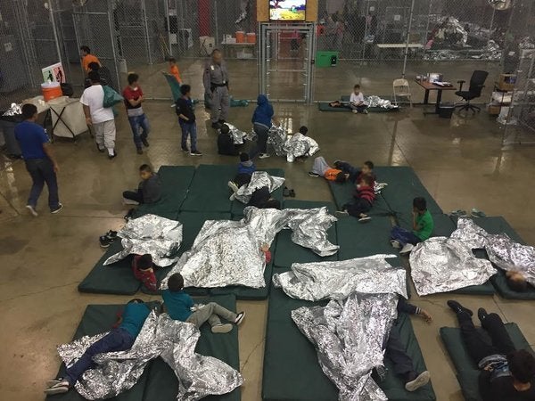 Migrant children are held in caged enclosures and given aluminum foil blankets in a McAllen, Texas detention facility.