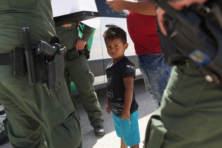 U.S. Border Patrol agents take into custody a father and son from Honduras near the U.S.-Mexico border on June 12, 2018, near Mission, Texas.