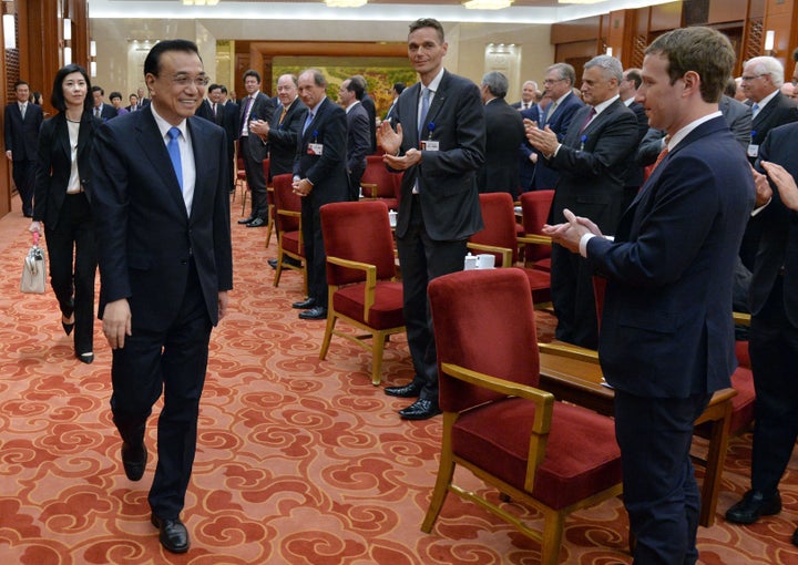 Facebook CEO Mark Zuckerberg, right, and the overseas representatives of the China Development Forum applaud as Chinese Premier Li Keqiang arrives for a March 21, 2016, meeting in Beijing.