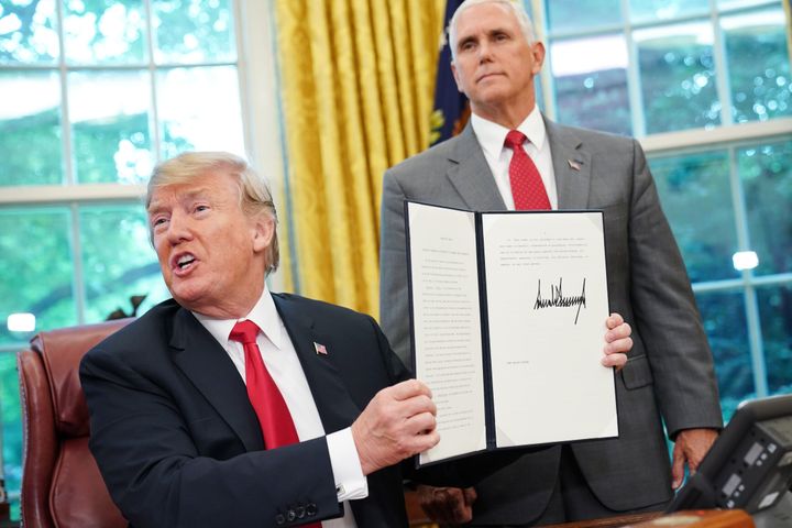 US President Donald Trump shows an executive order on immigration which he just signed in the Oval Office.