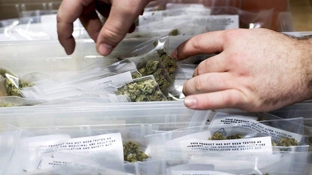 A worker stocks marijuana shortly before the first day of legalized recreational sales in California earlier this year. Calif
