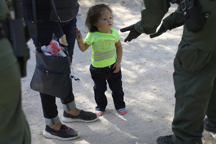 U.S. Border Patrol agents take Central American asylum seekers into custody on June 12 near McAllen, Texas. The immigrant families were then sent to a U.S. Customs and Border Protection processing center for possible separation.