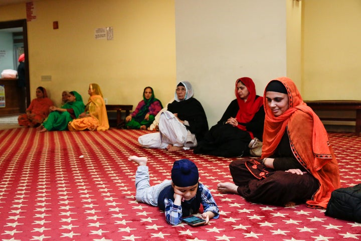 A child plays with a cellphone as followers of Sikhism pray at the the Sikh Cultural Society ahead of the annual Sikh Day Parade in Queens on April 27.