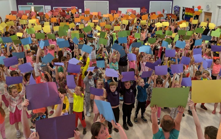 Children at <a href="https://www.dundeecity.gov.uk/service-area/children-and-families-service/education/downfield-primary-school" target="_blank">Downfield Primary School</a> hold up coloured card to make a 400-person rainbow flag.