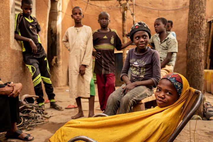 Ramatou (yellow veil), 12, and Daoussiya (in cap), 7, unaccompanied minors who are being returned to their familes in transit in Zinder, Niger