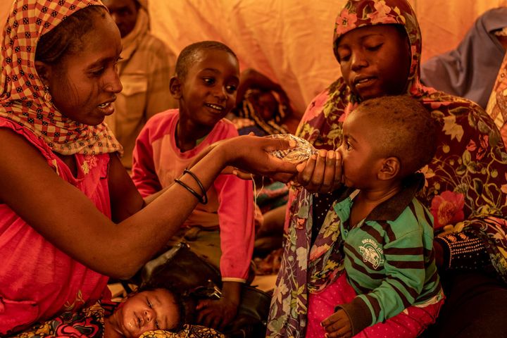 Women and children in a tent at a transit center for migrants who are being forcibly sent home from Algeria in Agadez, Niger
