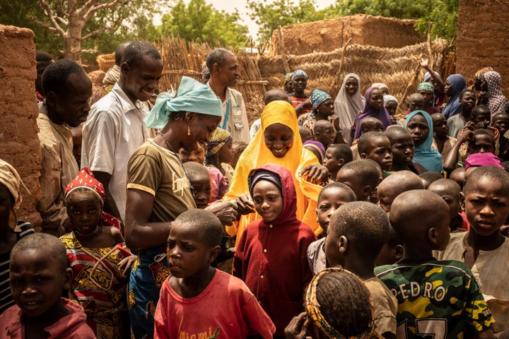 Daoussiya Gimai (in red), 7, meets her mother, Hassana (yellow veil) for the first time in four months since she left home to beg in Algeria