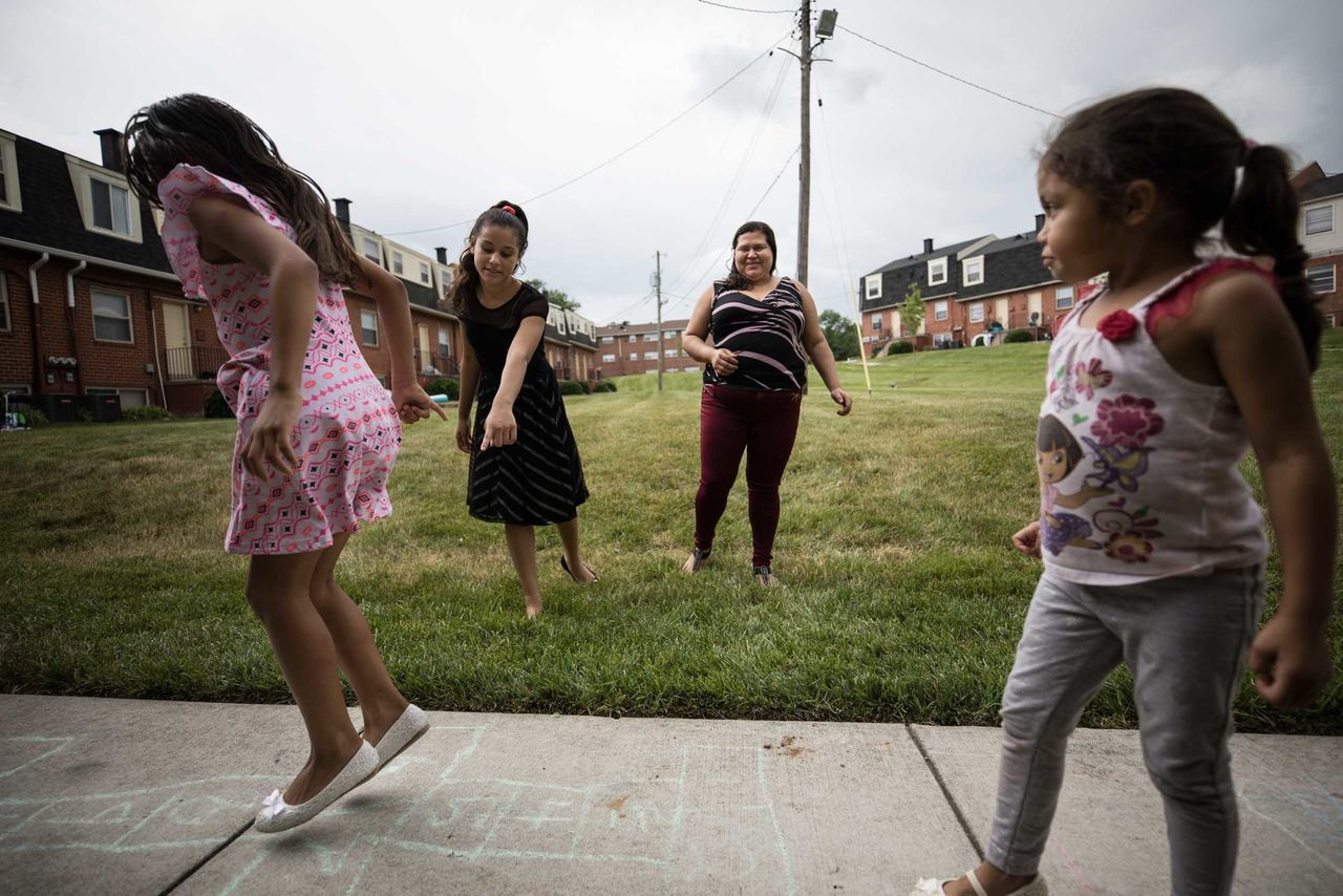 Martinez Yanez watches her daughters play outside the family's Baltimore apartment. 