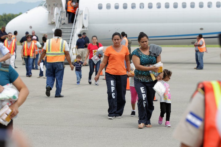 Women and their children walk on the tarmac at the Ramon Villeda international airport in San Pedro Sula, Honduras, after being deported from the U.S. on July 14, 2014.