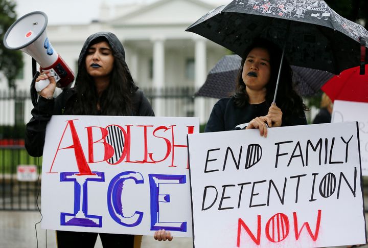 Two demonstrators protest President Donald Trump's immigration enforcement policies outside the White House. Last June he ended a program that was successful in keeping track of immigrant parents and kids in removal proceedings without having to keep them locked up.