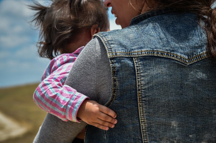 MCALLEN, TX - JUNE 29: Karina Lopez, a 23-year-old single mother from Guatemala carries her one-year-old daughter in her arms are being detained by Border Patrol after crossing illegally into the United States on Thursday, June 29, 2017