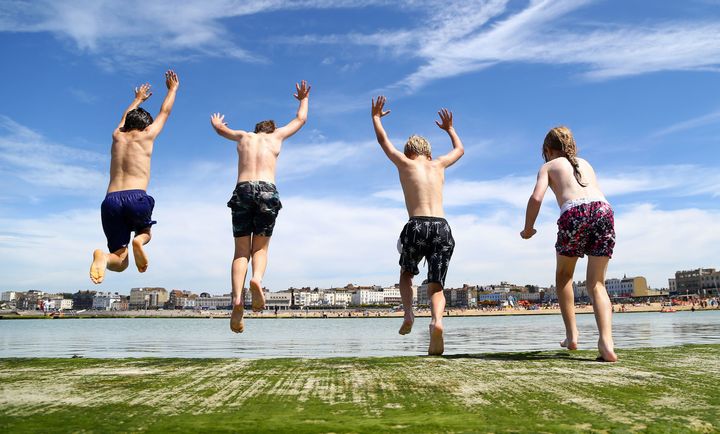 Children enjoy jumping into a sea pool in Margate, Kent.