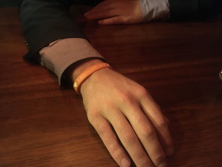 Gareth Rhodes shows a wristband with the words "Alyssa Strong." He bought it as part of a fundraiser to pay for the health care costs of a young woman with leukemia.