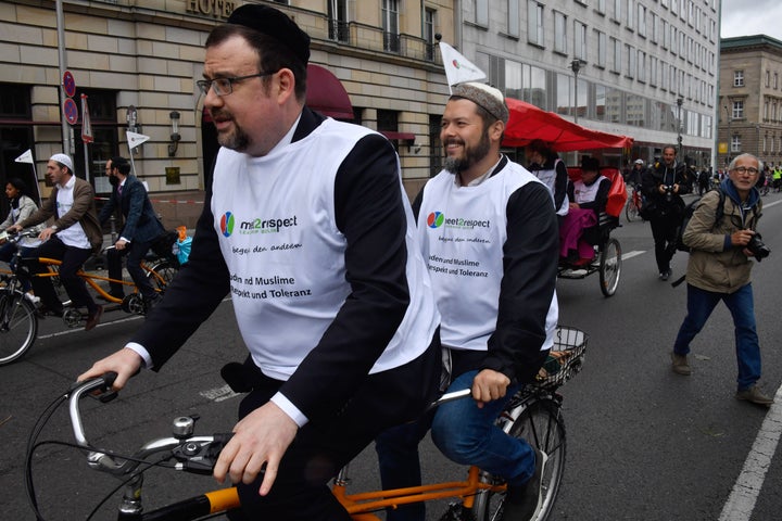 Imam Ender Cetin (back) and Rabbi Elias Dray (front) bike together in Berlin on June 24, 2018.