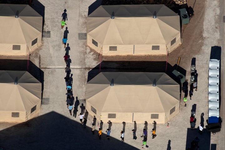 Immigrant children are led in single file between tents at a detention facility next to the Mexican border in Tornillo, Texas, on June 18, 2018. 