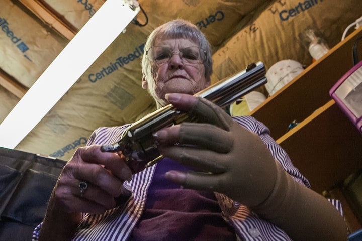 Dee Hill examines the last of the guns that once belonged to her husband, Darrell.