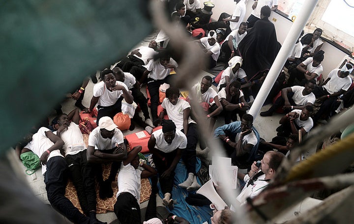 Migrants sit on the deck of the MV Aquarius, a search and rescue ship run in partnership between SOS Mediterranee and Medecins Sans Frontieres in the central Mediterranean Sea, June 12, 2018. 