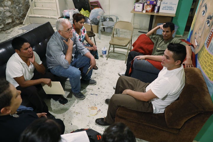 Garcia sits with migrants from Honduras and Guatemala at the Annunciation House migrant shelter.