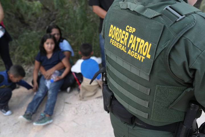Central American asylum seekers wait as U.S. Border Patrol agents take them into custody earlier this month near McAllen, Texas.