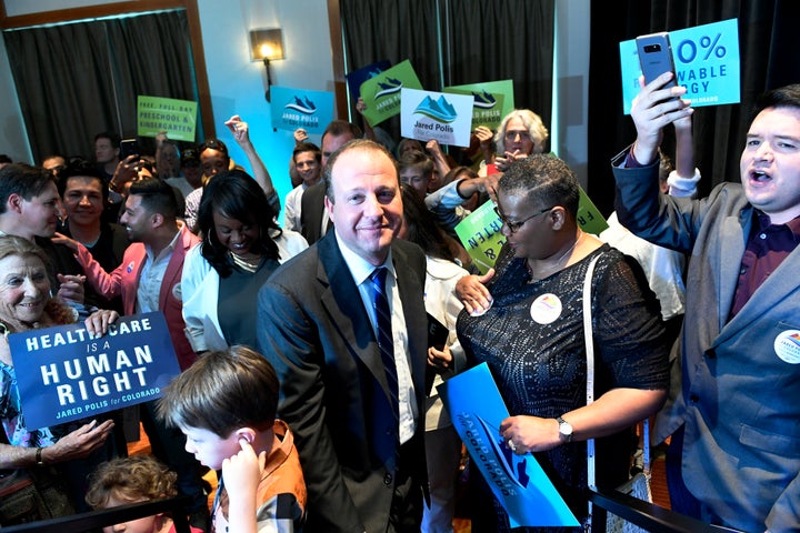 Democratic winner Jared Polis, with his son Caspian, 6, lower left, gets ready to go on stage to accept the nomination f