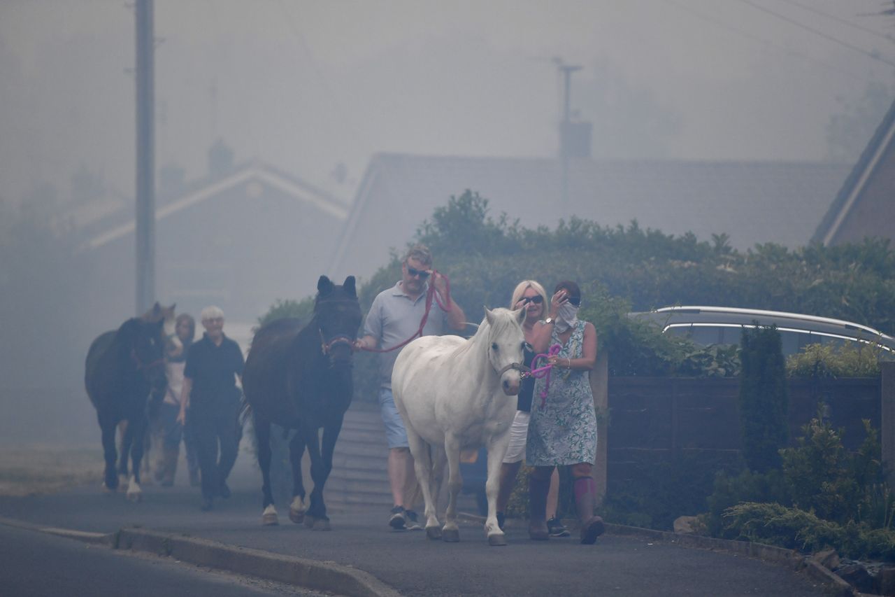 Horses are moved through heavy smoke in Carrbrook as residents were evacuated earlier.