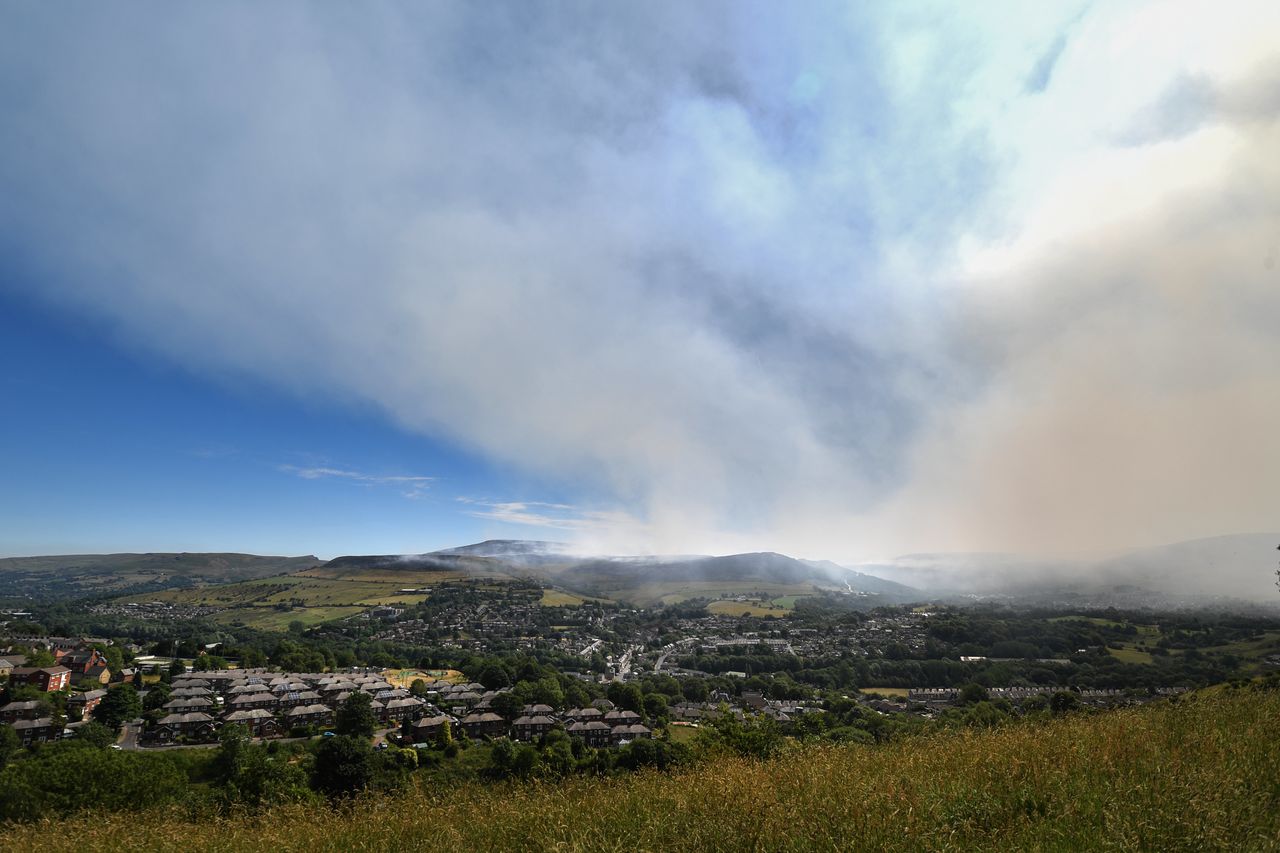 Plumes of smoke rise above Stalybridge as the wildfire enters a fourth day.