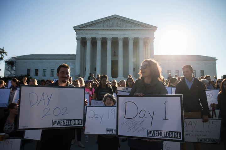 Demonstrators hold signs during a protest urging the U.S. Senate to hold a confirmation vote for Supreme Court nominee Merrick Garland on Oct. 4, 2016.