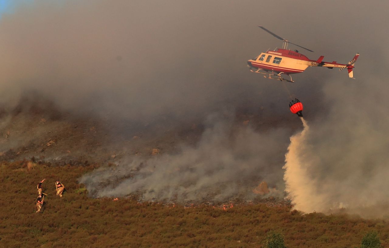 A helicopter drops water as firefighters tackled the blaze on Wednesday evening.