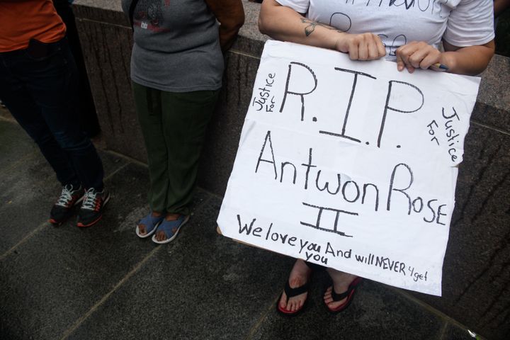 A woman holds a sign remembering Antwon Rose Jr. as she joins people gathered for Juneteenth celebrations on June 23 in Pittsburgh.