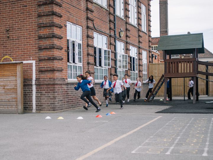 Schoolchildren run around their playground as part of a 'Marathon Kids' session.