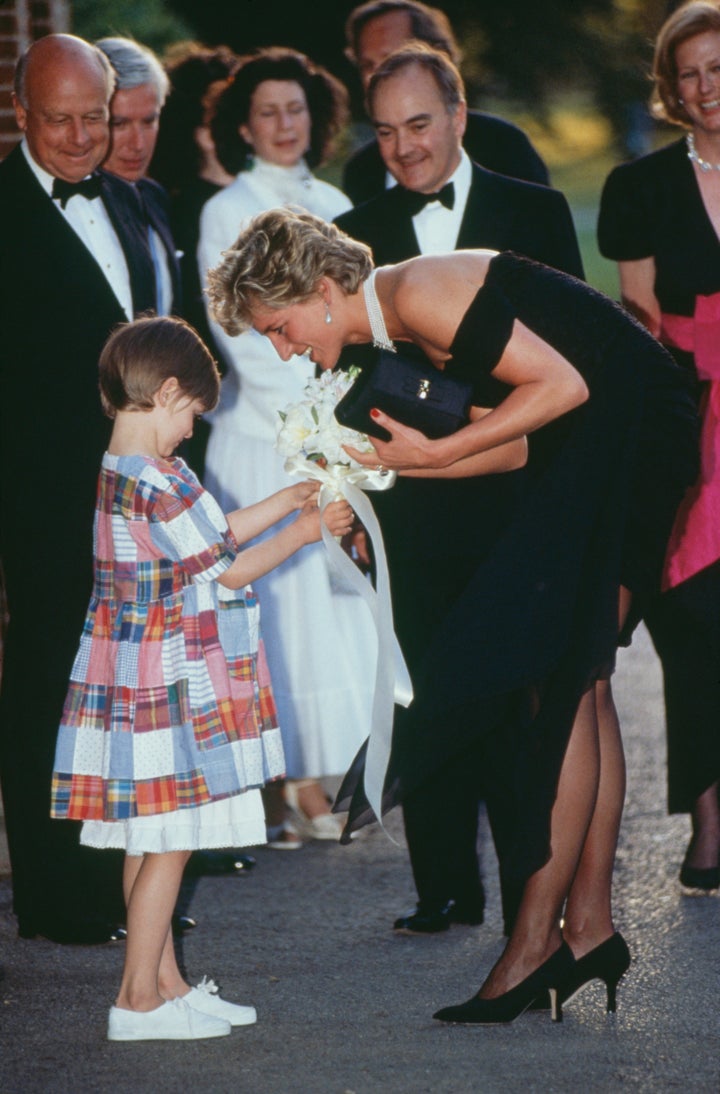 Diana receives a bouquet from a young girl as she arrives for the gala event at the Serpentine Gallery.