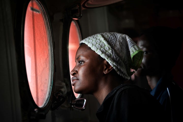 A migrant peers out from the porthole of the MV Aquarius upon its arrival at the Sicilian port of Messina, on May 14, 2018. 