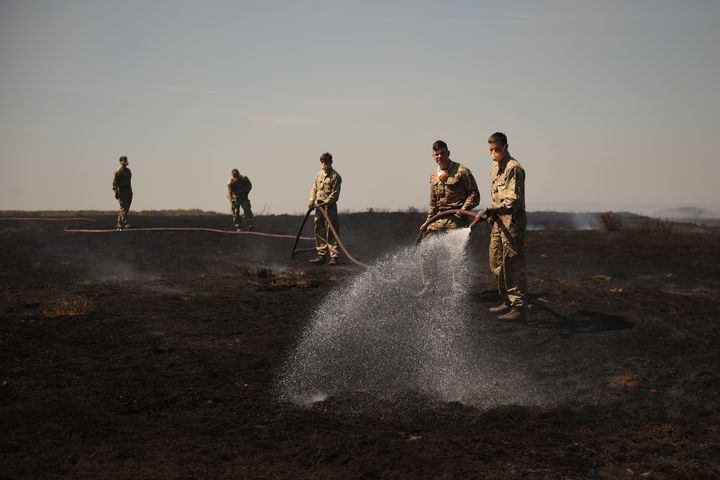 Soldiers are being asked to stay on to help contain a fire at Saddleworth Moor in northwest England