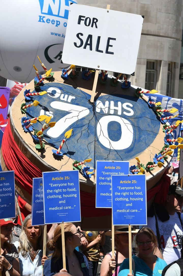 A giant NHS birthday cake with a 'for sale' sign in it was one of the hundreds of banners and placards at the rally.