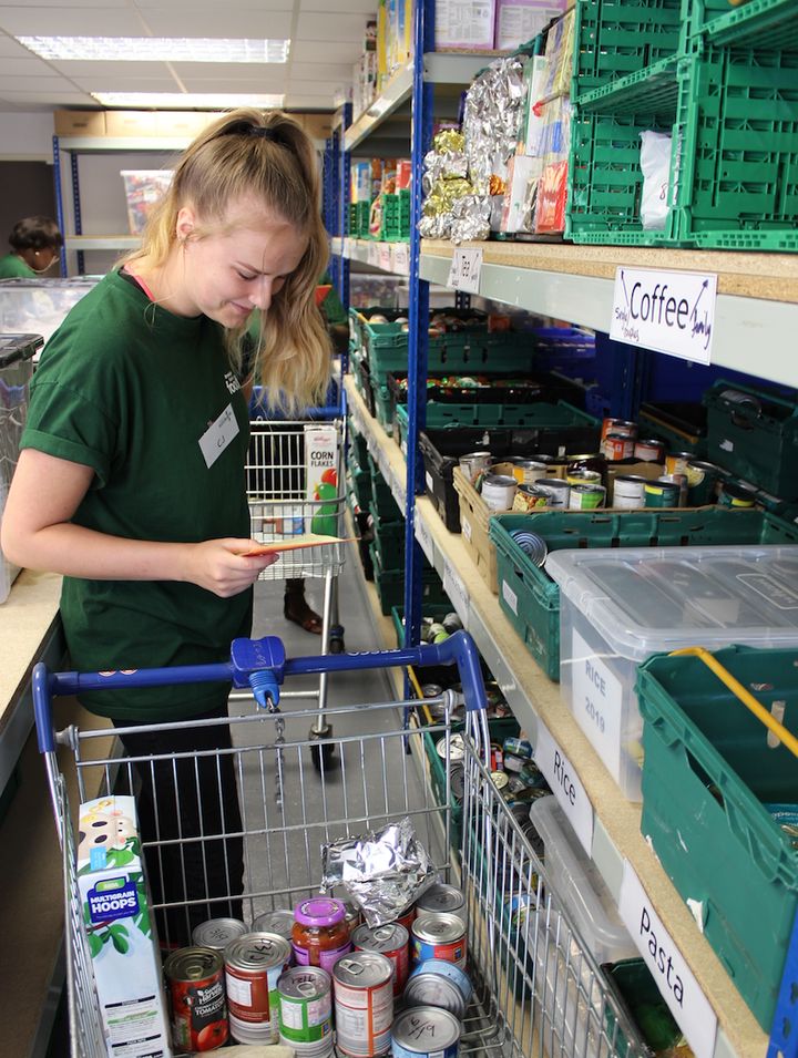 Birmingham Central Foodbank staff member CJ Glover collects items for a food package on a recent weekday. The service has helped up to 50 people a day in recent months.