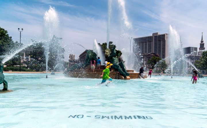 People try to cool off in a downtown fountain in sweltering heat in Philadelphia on Sunday.