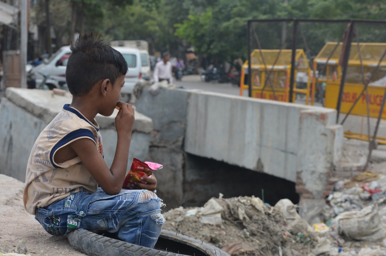 A child eating near a sewage canal at Kanti Nagar, New Delhi.