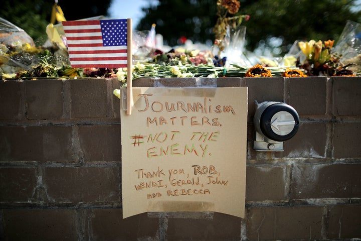 Flowers, notes and signs are placed at a makeshift memorial outside the Capital Gazette offices for the five employees killed by a gunman last week in Annapolis, Maryland.