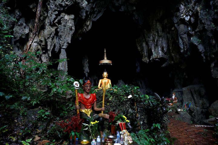 A spirit and Buddha state image outside in front of a cave near Tham Luang cave .