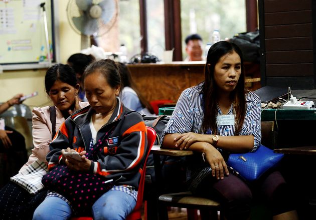 Family members wait for news near the cave.