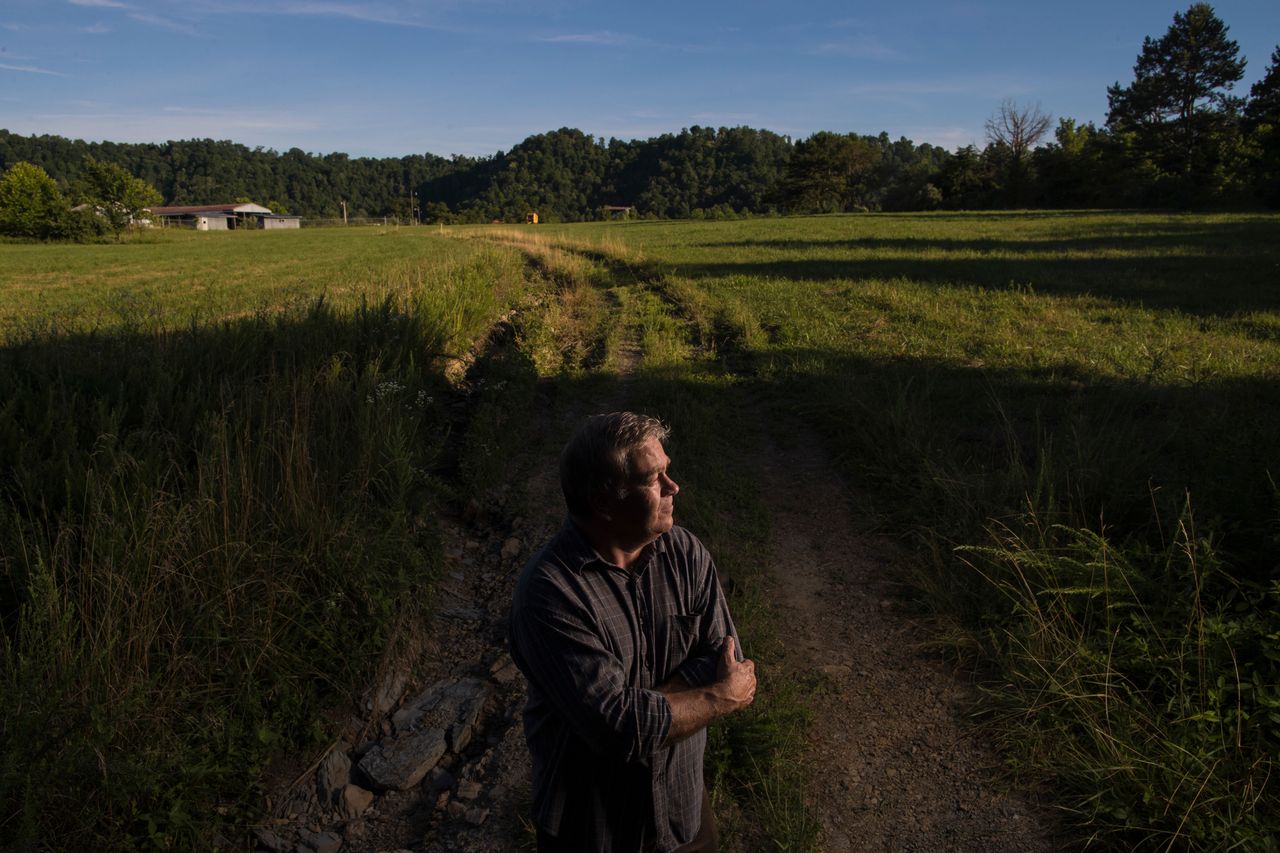Mitch Whitaker, 57, stands on top of a mountain that cast a shadow under which four generations of his family have made a home. It used to be taller, before the coal mines came and removed its top. A new federal prison is now proposed for the site.