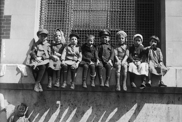 Children sit on a window ledge at an overcrowded immigration station at Ellis Island a century ago. When families arrived, they were kept together if possible. 