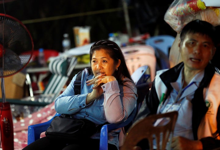 Family members of the trapped boys wait for news near the Tham Luang cave complex