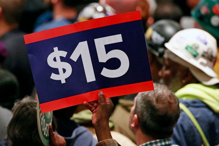 A supporter holds a sign while listening to Hillary Clinton speak at a rally in April 2016 to celebrate New York increasing the minimum wage to $15 an hour.