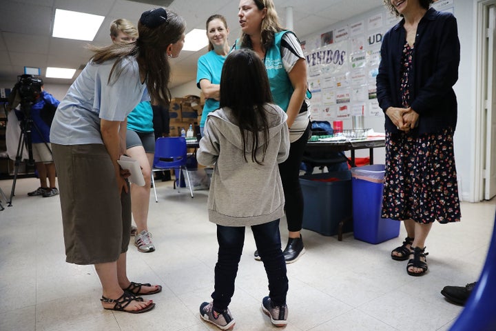 Jenquel, who recently crossed the U.S.-Mexico border with her mother and siblings, speaks with volunteers at the Catholic Charities Humanitarian Respite Center on June 21 in McAllen, Texas.