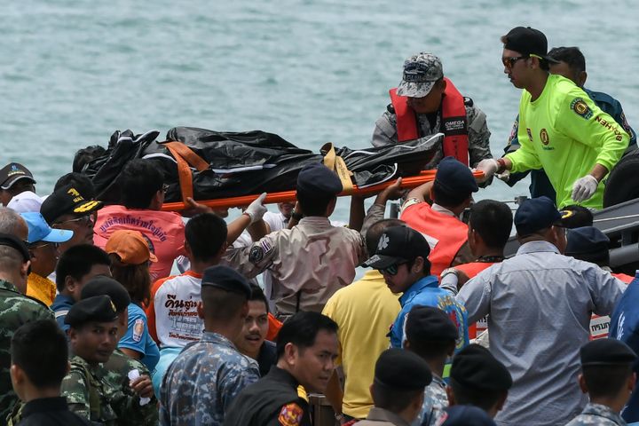 Thai rescue personnel carry a body bag bearing the recovered body of a passenger.