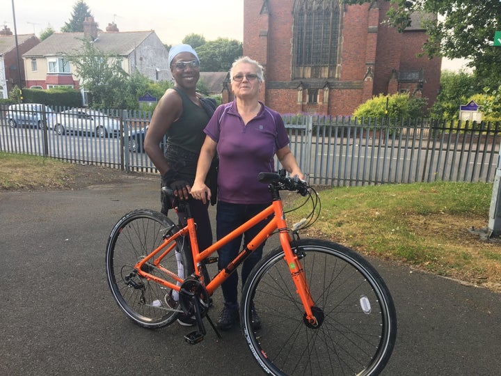 Cycle instructor, Catherine, and a participant, Janice, support women as they gain the skills to get on their bikes.