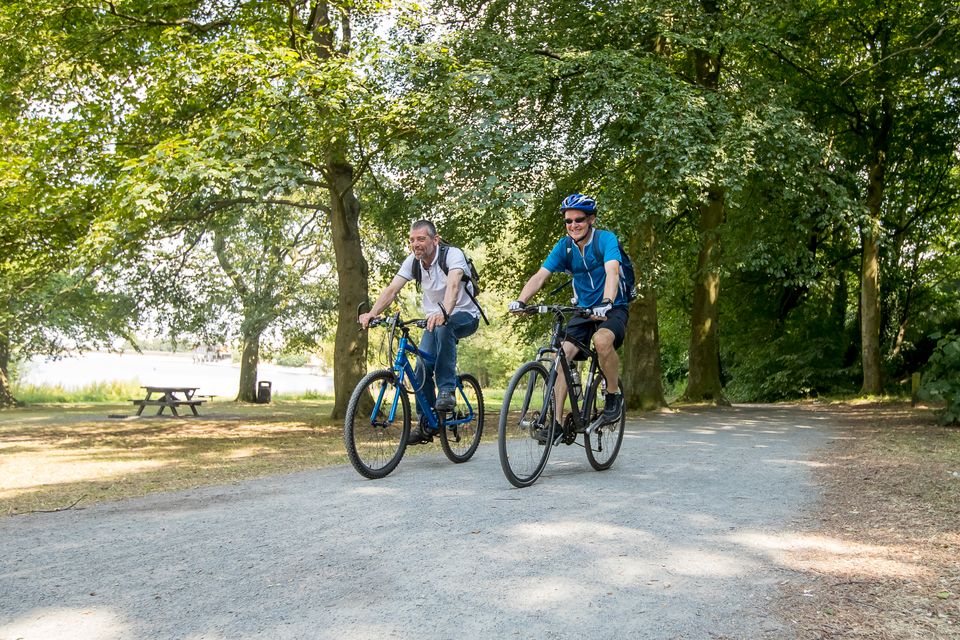 Two riders on the group riding next to the reservoir. 